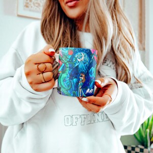 a woman is holding a coffee mug in her hands