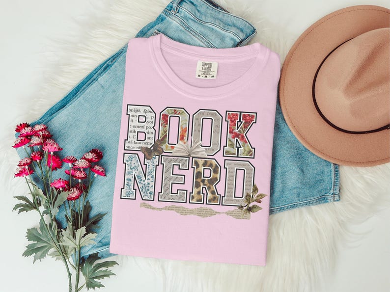 Pink t-shirt with "BOOK NERD" text in distressed, patterned letters.