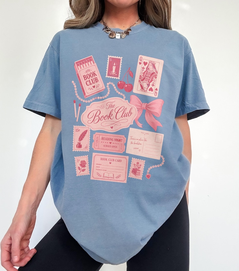 Blue t-shirt with pink "The Book Club" graphic featuring stamps, cards, and cherries.
