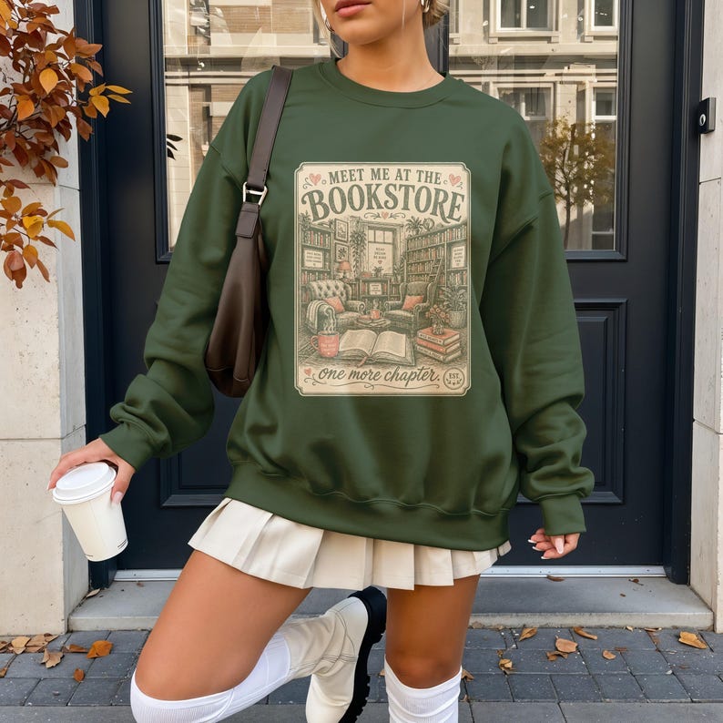 Green sweatshirt with "Meet me at the bookstore" book-themed graphic.