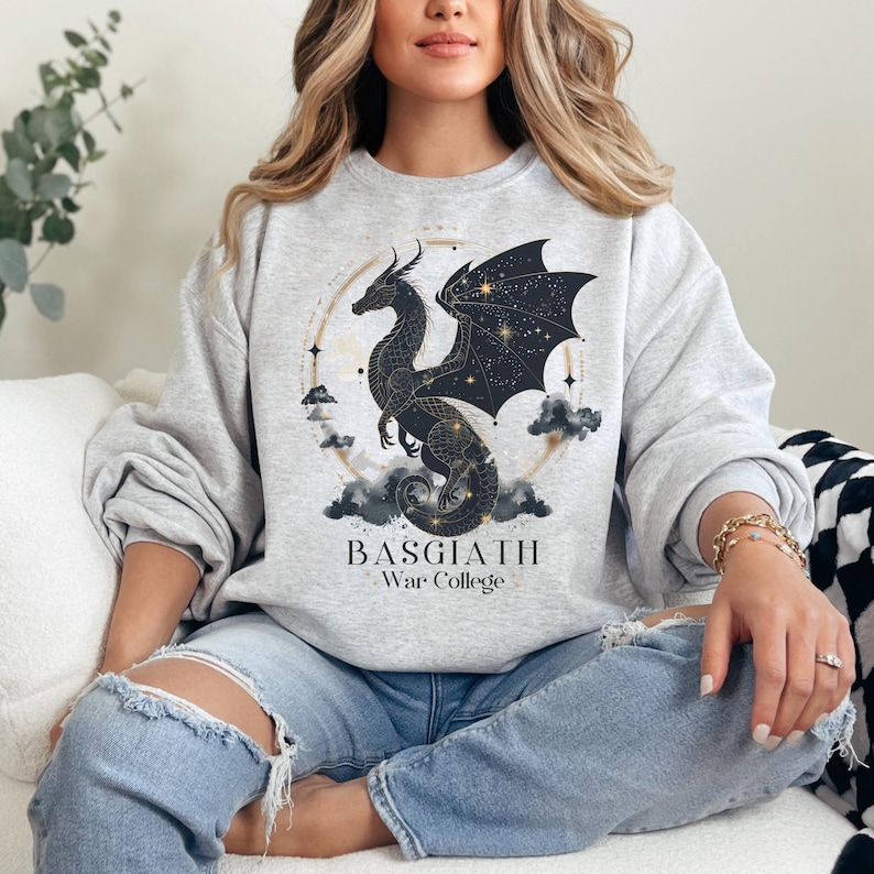 a woman sitting on a couch wearing a sweatshirt with a dragon on it