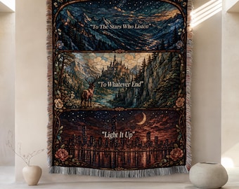 May include: A rectangular woven throw blanket featuring three horizontal panels with a stained glass aesthetic. The panels display a mountain landscape, a castle with a deer, and a city skyline at night, with the text To The Stars Who Listen, To Whatever End, and Light It Up.