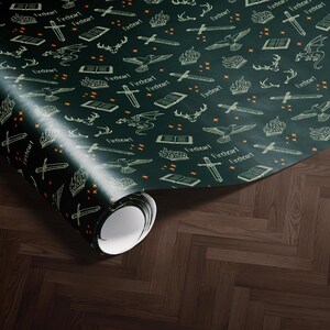 a roll of wrapping paper with a repeating pattern of various objects, including books, bats, and arrows, all rendered in a dark green color.