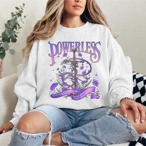 a woman sitting on a couch wearing a sweatshirt