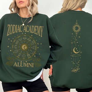 a woman is wearing a green zodiac sweatshirt