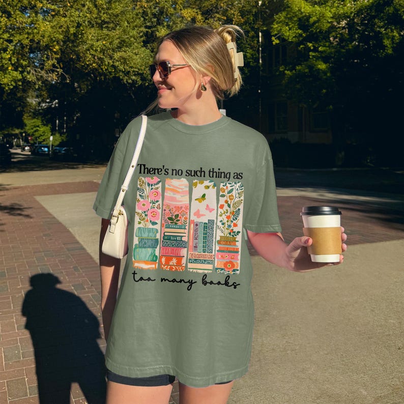 Woman wearing a graphic tee with "There's no such thing as too many books."