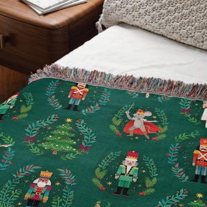 a bed with a green blanket with nutcrackers on it