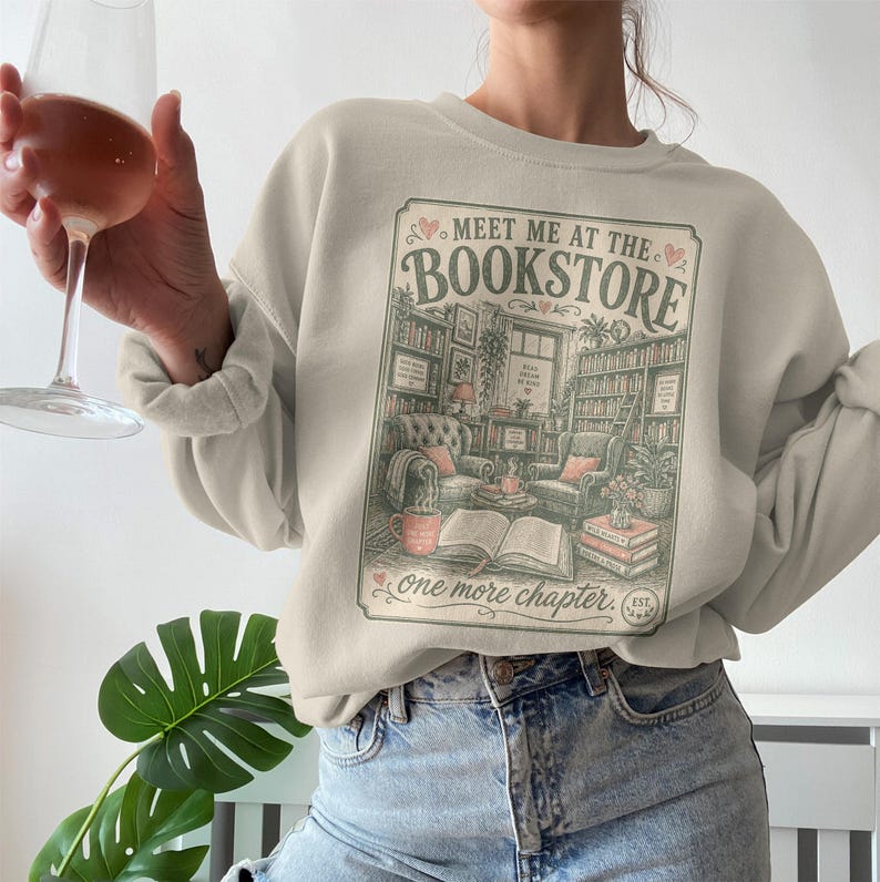 Cream sweatshirt featuring a vintage bookstore illustration and text about reading.