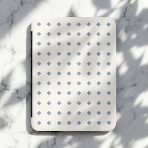 May include: A rectangular, cream-coloured tray featuring a repeating pattern of small, pale blue diamond shapes. The tray has rounded corners and a dark edge. The tray is on a marble surface with shadows.