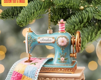 May include: A teal sewing machine ornament with gold accents and a pink spool. The ornament has the name "Amelia" on it and a colorful patchwork quilt. The text "PERSONALIZED DESIGN CUSTOM TEXT & IMAGE" is in the upper left corner.