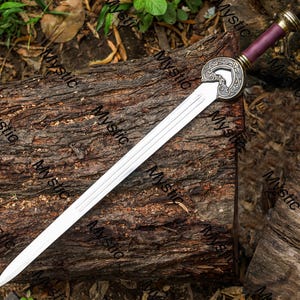 Puede incluir: Una espada plateada con una empu&ntilde;adura decorativa y un mango morado descansa sobre un tronco de madera desgastado. La espada presenta un dise&ntilde;o circular detallado cerca de la base de la hoja y un borde afilado pulido. El mango tiene detalles dorados.