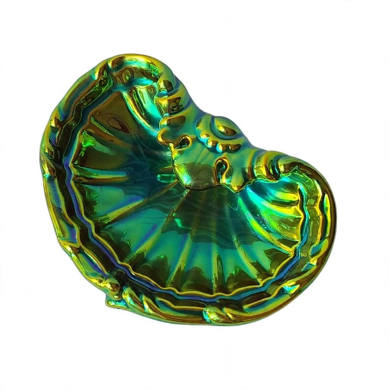 Peut inclure: Un plat en forme de coquillage avec une finition iris&eacute;e brillante qui alterne entre des nuances vibrantes de vert &eacute;meraude, de bleu profond et de jaune dor&eacute;. La surface pr&eacute;sente une texture radiale en &eacute;ventail avec des bords incurv&eacute;s.