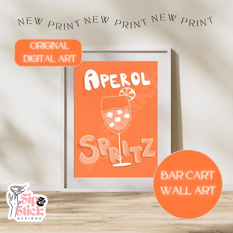 May include: Orange and white printable wall art featuring a glass of Aperol Spritz with the text "Aperol Spritz" in a stylized font. The text "Bar Cart Wall Art" is also included in the image.