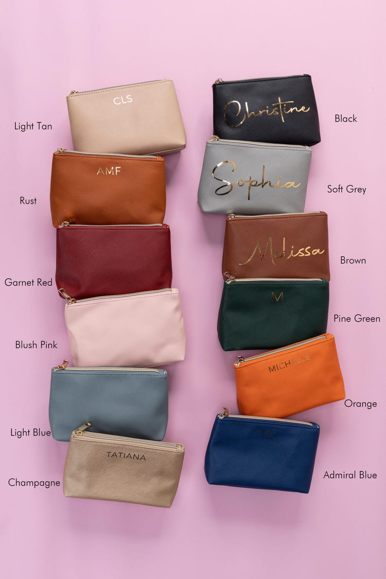 May include: Ten different colored zippered pouches with gold lettering. The pouches are arranged in two rows of five. The colors are light tan, rust, garnet red, blush pink, light blue, champagne, black, soft grey, brown, pine green, orange, and admiral blue.