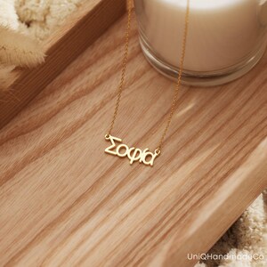 May include: A gold necklace with the name "Sophia" spelled out in cursive.