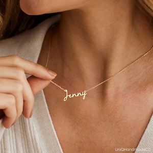 May include: A gold necklace with the name "Jenny" written in cursive script.