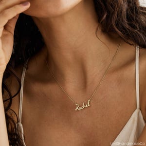 May include: A gold necklace with the name "Rachel" written in cursive script.