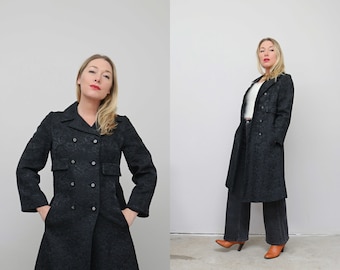 May include: A black double-breasted coat with a floral pattern. The coat has a fitted waist and a flared skirt. The model is wearing the coat with a white top and black pants.
