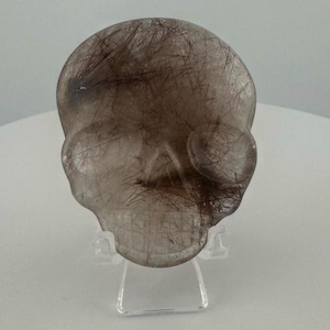 Red Rutile in Quartz Magical Child Palm Skull carved by Leandro de Souza