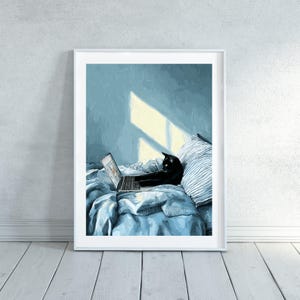 May include: A framed art print depicts a black cat using a laptop while lounging on a bed. The cat is positioned on a blue comforter with a striped pillow. The background features a blue wall with sunlight streaming through a window.