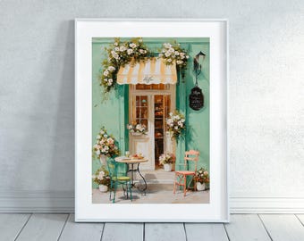 May include: A framed art print of a cafe scene. The teal exterior has a yellow and white striped awning with the word "Coffee" and a door decorated with flowers. A small table and chairs are set outside the cafe.