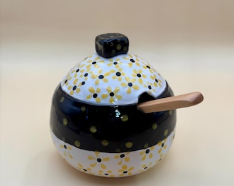 Handmade, hand painted, sugar bowl with small daises painted around the lid.