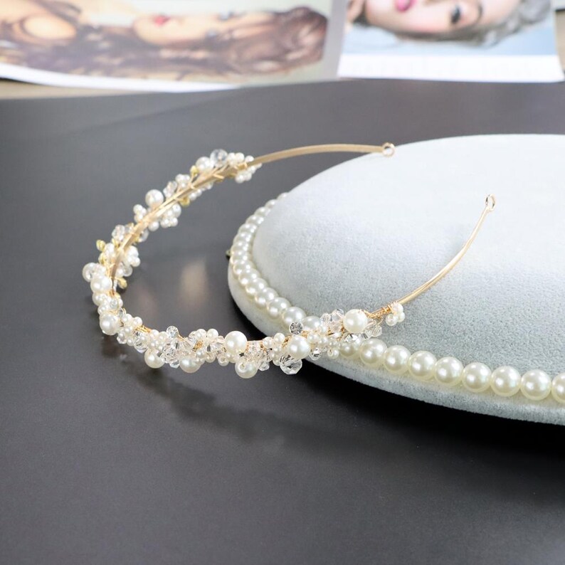 May include: A gold-toned bridal headband with faux pearls and clear crystals. The delicate design features a thin band and clusters of pearls and crystals, perfect for weddings or special occasions.