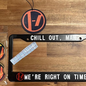 Puede incluir: Marco de matrícula negro con el texto "Chill Out, Man" en la parte superior y "We're Right On Time" en la parte inferior. El marco tiene un logotipo rojo con el número "17" en él. También se incluyen dos posavasos para coche con el mismo logotipo.