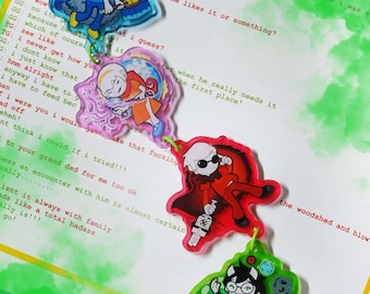 May include: A multi-part acrylic keychain featuring four distinct character charms connected by lime green jump rings and a lime green lobster clasp. Each charm displays a unique illustrated figure in a vibrant color palette of blue, orange, red, and black.