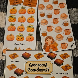 Puede incluir: Un conjunto de 10 pegatinas con temática otoñal que presentan lindas ilustraciones de calabazas, tazas de café y libros. Las pegatinas están impresas en papel blanco con un acabado mate. El texto en las pegatinas dice "¡Adopta una calabaza bebé!" "Solo 3 € cada una" "Caminando conscientemente hacia la tranquilidad" "Buenos libros y buena compañía" "Tira y ahorra" "O ahorra 2 € cada una" y "1 € cada una".
