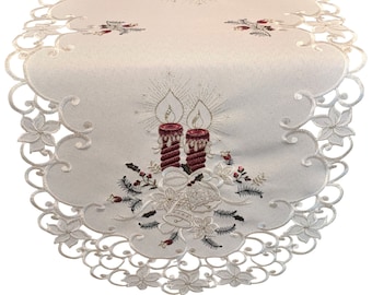 May include: White oval table runner with an embroidered design of two red candles with gold flames and a floral motif. The runner has a scalloped edge.
