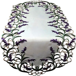 May include: An oval-shaped table runner featuring a white center panel bordered by intricate cutwork embroidery. The design showcases purple lavender sprigs with green stems and leaves, creating a decorative scalloped edge around the perimeter.