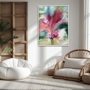 Pu&ograve; includere: Dipinto floreale astratto in una cornice bianca. L'opera presenta una vibrante composizione di tonalit&agrave; rosa, rosse e verdi, con un focus su una forma centrale a forma di fiore. Il dipinto &egrave; esposto in una stanza luminosa e ariosa con luce naturale.