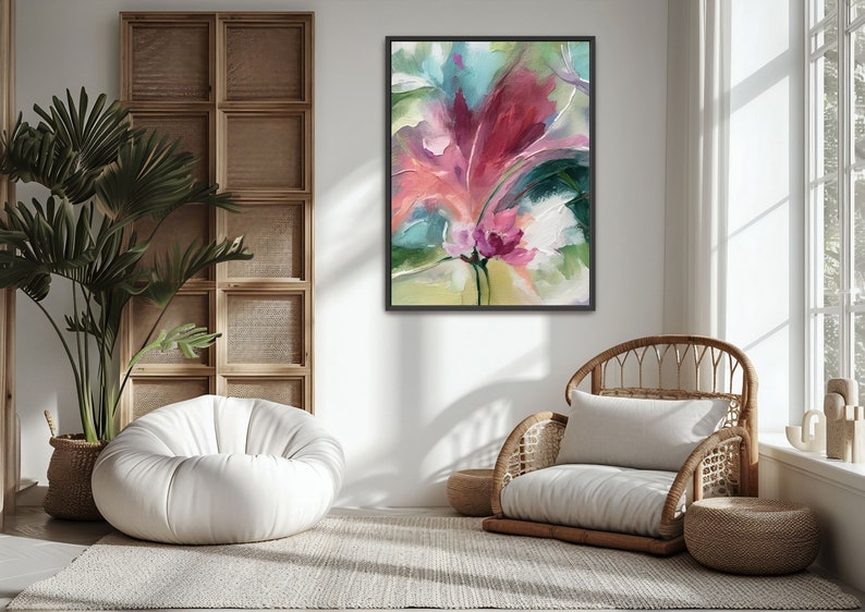 Pu&ograve; includere: Stampa artistica floreale astratta in cornice nera. L'opera presenta una vibrante composizione di pennellate rosa, rosse, verdi e bianche, evocando un senso di natura e tranquillit&agrave;. Il dipinto &egrave; esposto in una stanza luminosa e ariosa con una sedia in vimini e un pouf bianco.