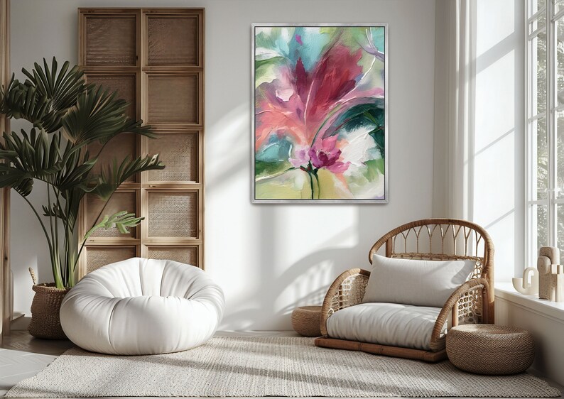 Pu&ograve; includere: Dipinto floreale astratto in cornice argentata. L'opera presenta una vibrante composizione di pennellate rosa, rosse, verdi e bianche. Il dipinto &egrave; appeso sopra una sedia in vimini e una poltrona a sacco bianca in una stanza luminosa e ariosa.