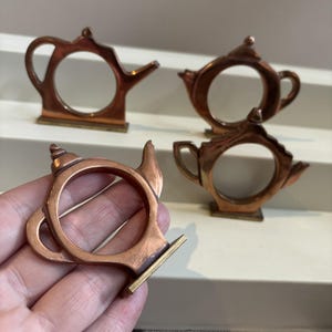 May include: A set of three ceramic mugs with a speckled, matte finish. The mugs are in shades of cream, light gray, and dark gray. Each mug has a simple, minimalist design, perfect for coffee or tea.