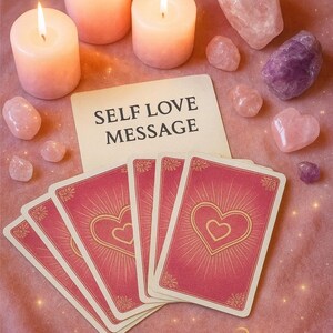 Könnte beinhalten: Ein Stillleben mit brennenden Kerzen, Kristallen und Tarotkarten. Die Karten haben ein Herzdesign auf der Rückseite. Der Text "SELF LOVE MESSAGE" befindet sich auf einer Karte. Das Bild ist auf einer rosa Oberfläche platziert. Der Text "REIKI BY Mel" befindet sich unten.
