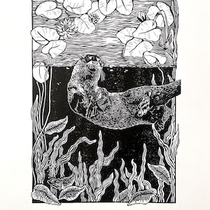 Könnte beinhalten: Schwarz-Weiß-Linolschnitt eines Otters, der in einem Teich schwimmt. Der Otter ist von Seerosen, Wasserpflanzen und Fischen umgeben. Das Kunstwerk hat einen hohen Kontrast und ein detailliertes, strukturiertes Aussehen.