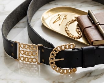 Cinturón vintage de cuero azul marino con hebilla de cadena dorada, estilo años 80.