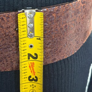 this is a pretty wide belt 2.3” with quality brown rusted look thick Italian leather.