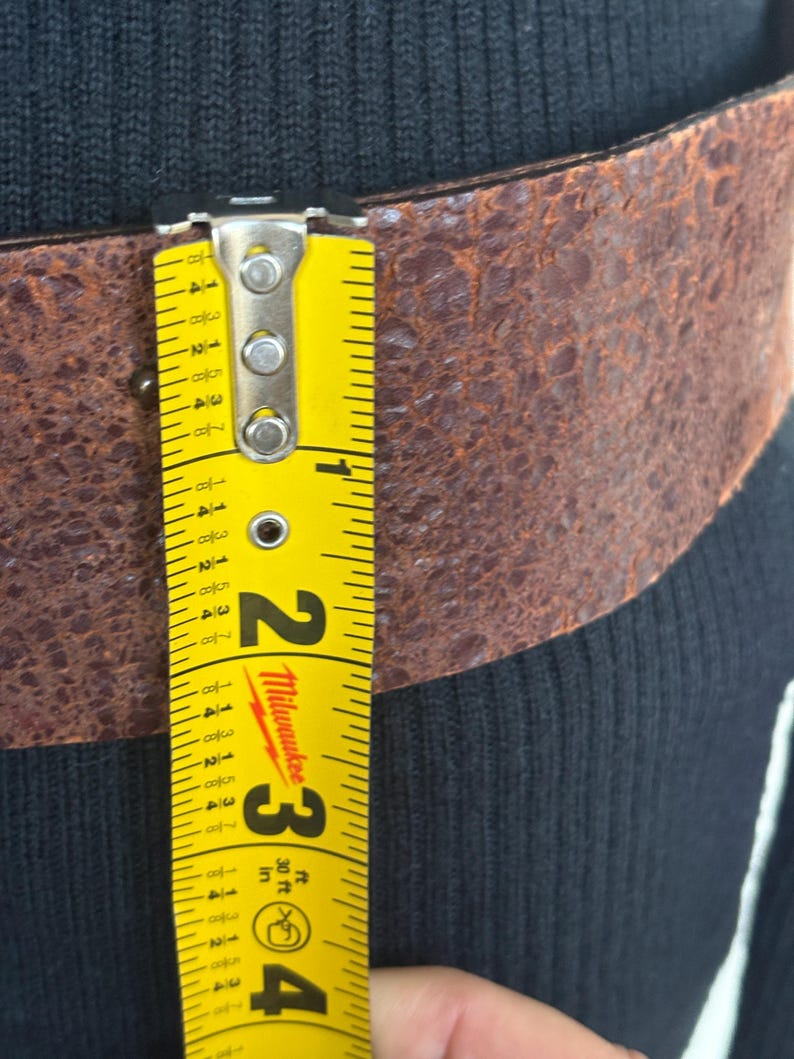 this is a pretty wide belt 2.3” with quality brown rusted look thick Italian leather.