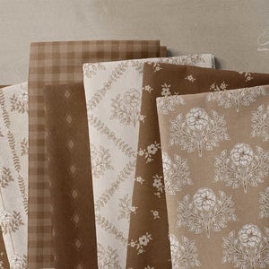 Bolts of fabric featuring a collection of brown and beige hand drawn floral patterns