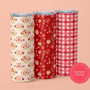 May include: Three insulated tumblers with strawberry designs. One has a white and red fan pattern, another a red strawberry pattern, and the third a red and white gingham pattern. A pink sticker reads "Strawberry Delicious."