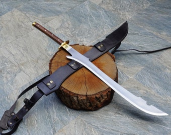 May include: A silver sword with a wooden handle and a leather scabbard. The sword is lying on a wooden log with the scabbard wrapped around it.