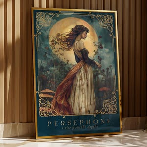 Op de afbeelding: Een ingelijste kunstdruk met een vrouw in een vloeiende jurk, tegen een achtergrond van een grote maan en een mystieke tuin. De print heeft een teal rand met gouden accenten en de tekst "PERSEPHONE I rise from the depths".