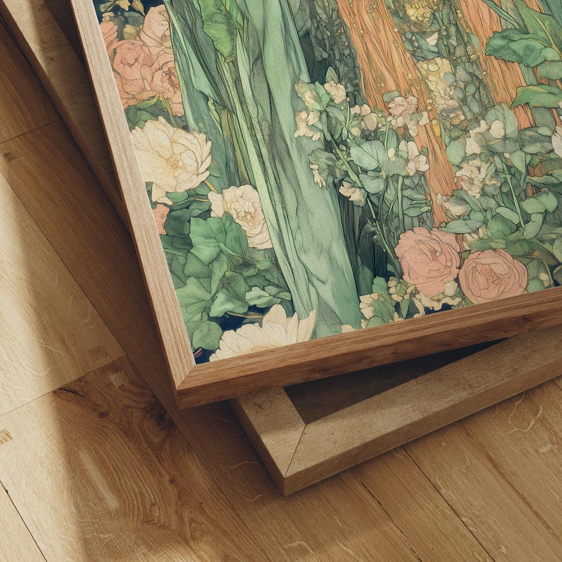 May include: A framed art print featuring a floral illustration with soft green, peach, and white tones. The artwork is set in a natural wood frame, with a second, similar frame visible below. The composition includes roses and other flowers.