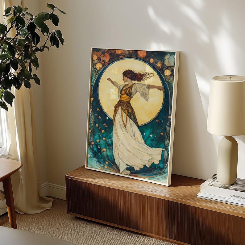 May include: A framed wall art print featuring a figure with flowing hair and arms outstretched, wearing a white and gold dress. The background displays a large, glowing yellow moon surrounded by deep teal tones and small, scattered floral elements.
