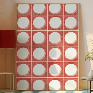 May include: A framed print of a geometric pattern with white circles on a red background. The print is hanging on a wall with a light pink color. The floor is tiled with a blue and white diamond pattern.