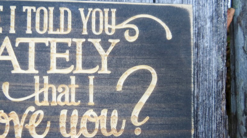 May include: A dark wood sign with white lettering that reads "Did I tell you lately that I love you?"
