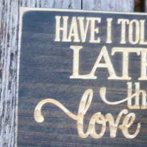 May include: A dark brown wooden sign with white lettering that reads "Have I told you lately that I love you".